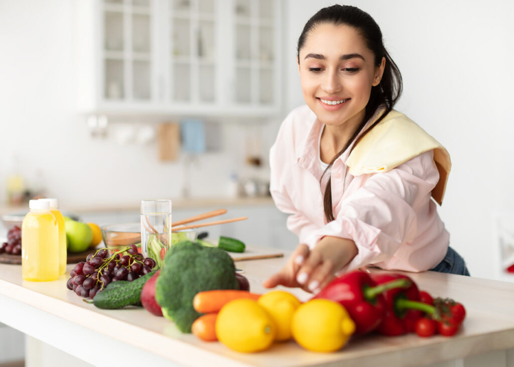 moçca na cozinha preparando um refeição com frutas e legumes