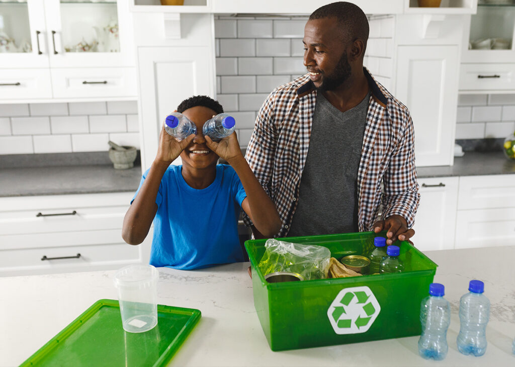 adulto orientando a criança a separar itens para reciclagem