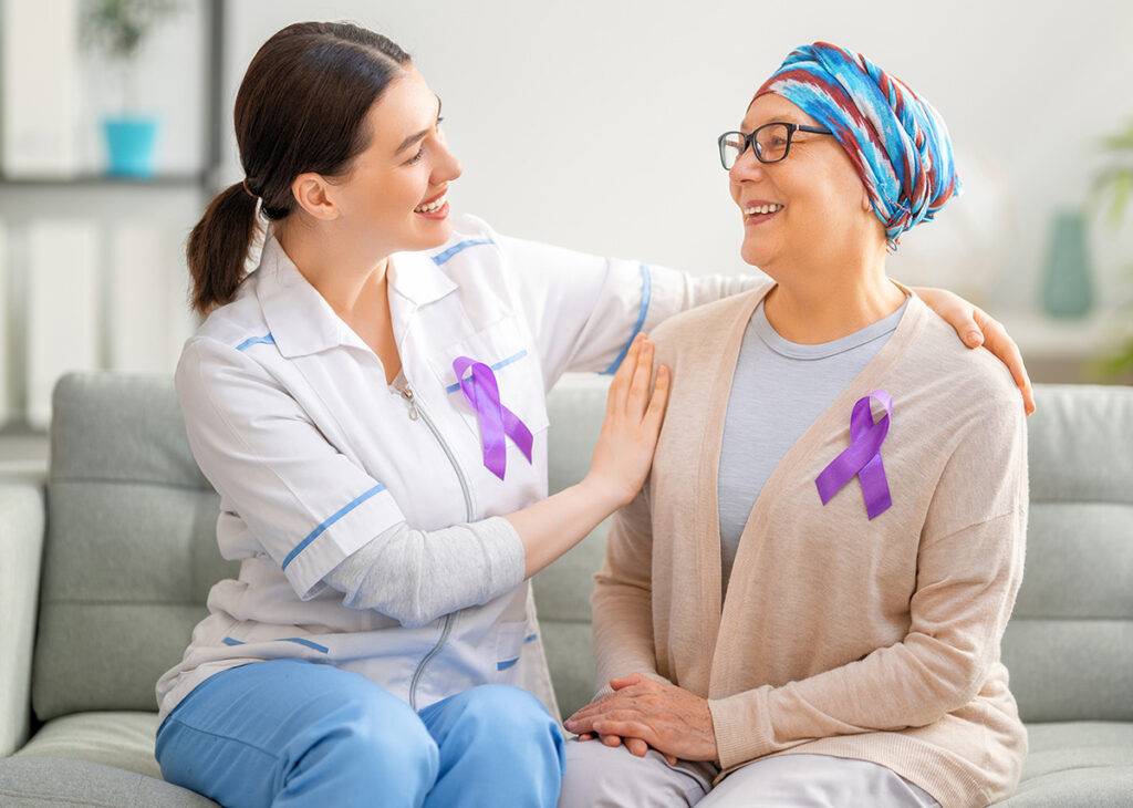médica e paciente com câncer, conversando e sorrindo