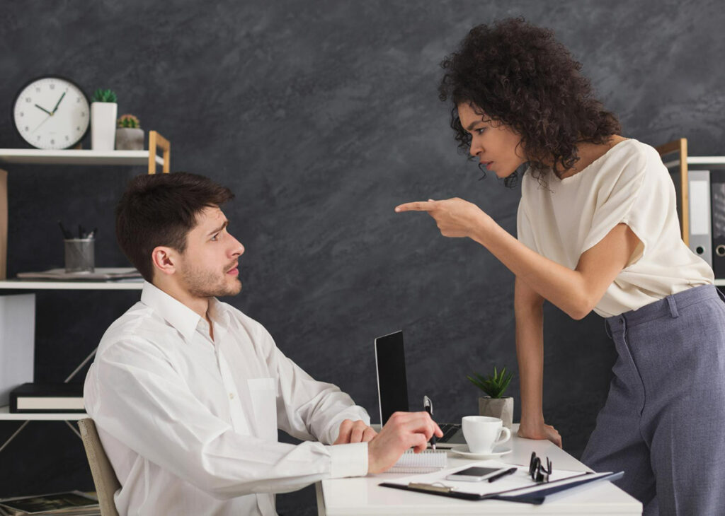 pessoal brava apontando na cara do colega de trabalho.